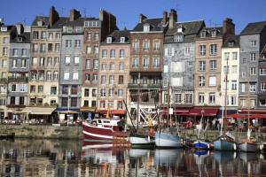 a group of boats docked in a harbor with buildings at Le Jardin de Sasha in Équemauville