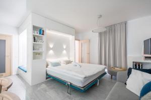 um quarto branco com uma cama e um sofá em Warta River Comfort Apartment em Poznań