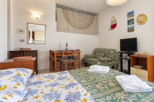 a bedroom with a bed and a chair and a television at Monolocale vista mare in Badesi