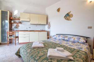 a small bedroom with a bed and a kitchen at Monolocale vista mare in Badesi