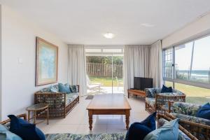 een woonkamer met banken en een tafel en een televisie bij 7 Kenwyn On Sea in Ballito