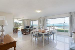 een eetkamer met een tafel en stoelen bij 7 Kenwyn On Sea in Ballito