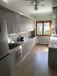 cocina con armarios blancos y fogones en Serravalle Apartment 2, en Serravalle Scrivia