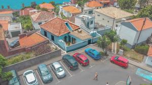 una città con auto parcheggiate in un parcheggio di Ouri in Blue House a Jardim do Mar