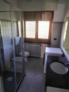 La salle de bains est pourvue de toilettes, d'un lavabo et d'une douche. dans l'établissement Serravalle Apartment 2, à Serravalle Scrivia