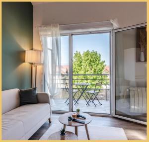 una sala de estar con sofá y una gran puerta corredera de cristal en Appartement T2 Moderne Neuf Collonge, en Collonges-sous-Salève