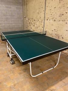 una mesa de ping pong en una habitación con una pelota de ping pong en Les Quais de la Vesdre, en Verviers