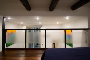 una camera con un letto e una parete di vetro di Tom apartments a Napoli