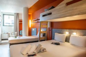 1 Schlafzimmer mit 2 Betten und 1 Etagenbett in der Unterkunft ibis budget Paris Porte de Pantin in Pantin