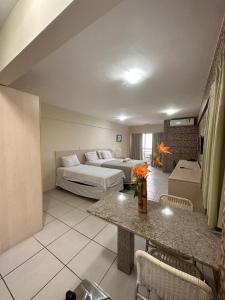 a hotel room with a bed and a living room at Terrazzo Ponta Negra Flat in Natal