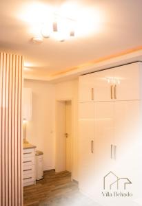 een keuken met een witte kast in een kamer bij Belrado Apartments in Belgrado