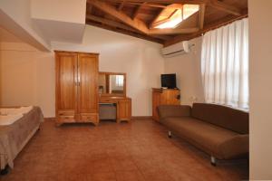 a bedroom with a couch and a desk and a mirror at Ford Hotel in Adrasan