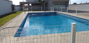 een zwembad achter een hek voor een gebouw bij Casa do Chino 