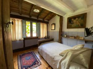 a bedroom with a bed and a window at El Invernal de Vallobera in Pujayo