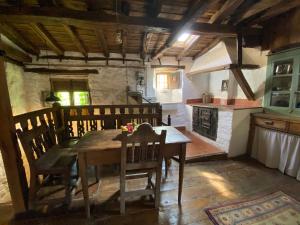 a dining room with a wooden table and a kitchen at El Invernal de Vallobera in Pujayo