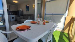 uma mesa branca com placas de laranja e guardanapos em Victoria - Les Cles de l'Esterel em Théoule-sur-Mer