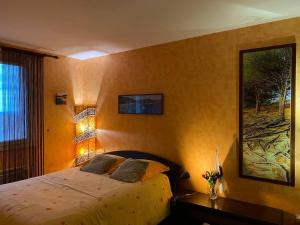 ein Schlafzimmer mit einem Bett und einem Gemälde an der Wand in der Unterkunft Maison au calme piscine mer au coeur de la nature U Nuciolu in Talasani + 51 Fotos