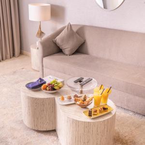 a living room with a coffee table with food on it at Argan Al Bidaa Hotel and Resort , Kuwait in Kuwait