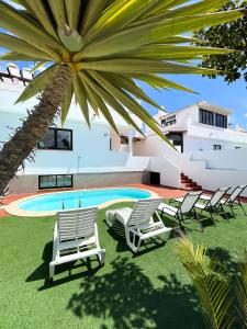 un gruppo di sedie a sdraio accanto alla piscina di Laguna Home by Best Holidays Fuerteventura a Corralejo