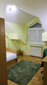 een slaapkamer met een bed en een groen tapijt bij Spacious and quiet apartment in Skopje