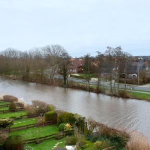 una vista de un río con una casa en el fondo en Tanjasfewo - b42582 en Dornum