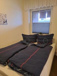 1 cama con 2 almohadas y ventana en Tanjasfewo - b42582 en Dornum