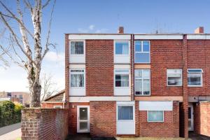 a red brick building with white windows and a tree at Beautiful house in North Oxford in Oxford