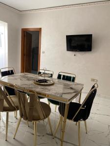 stół jadalny z krzesłami i telewizor na ścianie w obiekcie Luxury Appartement Tanger w mieście Tanger