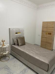 biała sypialnia z łóżkiem i komodą w obiekcie Luxury Appartement Tanger w mieście Tanger