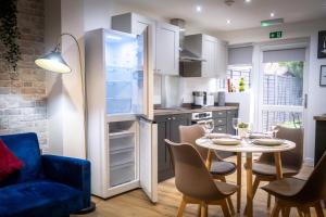 a kitchen and dining room with a table and a refrigerator at The Bark House by Night Stay in Birmingham