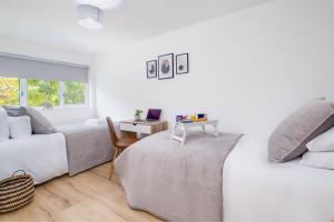 a white room with two beds and a desk at The Bark House by Night Stay in Birmingham
