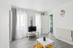 - un salon blanc avec une télévision et une table dans l'établissement Chic apart downtown Paris, à Paris