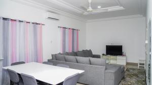 un soggiorno con divano, tavolo e TV di MUSA SILLAH a Sukuta