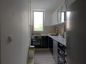 eine Küche mit weißen Schränken und einem Fenster in der Unterkunft Lux Apartment Sarajevo in Sarajevo