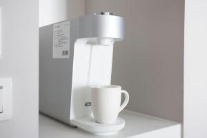 a coffee machine with a cup on a counter at Manho Hotel in Taichung