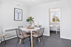 Un comedor con una mesa y sillas blancas. en Scandi-chic Riverside Hideaway Near Attractions, en Hobart