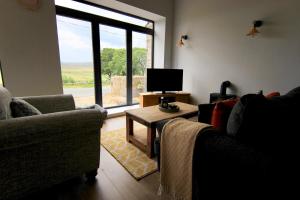 a living room with two couches and a tv at Farways Den in Haworth
