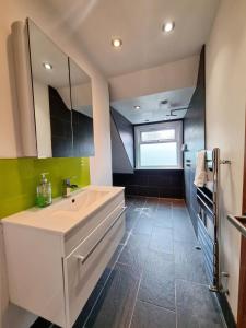 baño con lavabo grande y espejo en Bright top floor, 1 bed apartment in great location, en Londres