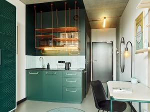 a kitchen with green cabinets and a table at Basecamp Wroclaw in Wrocław