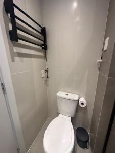 a bathroom with a white toilet and a roll of toilet paper at Loft no Bairro Auxiliadora in Porto Alegre +25 photos
