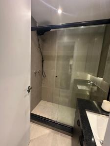 a shower with a glass door in a bathroom at Loft no Bairro Auxiliadora in Porto Alegre