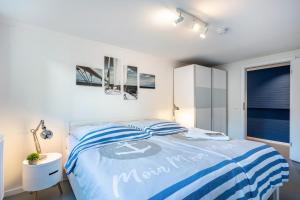 Schlafzimmer mit einem Bett mit einer blauen und weißen Bettdecke in der Unterkunft Meerlust Travemünde in Travemünde