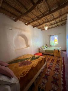 a bedroom with two beds and a rug at Riad Auberge Bassou in Nkob