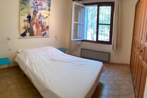 1 dormitorio con cama blanca y ventana en Villa Le Sommet - Vidauban, en Vidauban