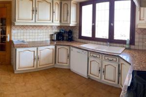 una cocina con armarios blancos y fregadero en Villa Le Sommet - Vidauban, en Vidauban