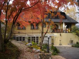 ein Haus im Herbst mit roten Blättern in der Unterkunft Hotel Restaurant - Häuserl im Wald Graz in Graz