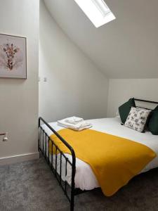 Un dormitorio con una cama con una manta amarilla. en Quirky getaway @ The Old Bakery en Bristol