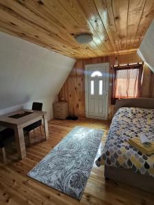 Village Cottage في زبلجك: غرفة نوم بسرير ومكتب وطاولة