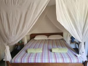 a bed in a tent with two pillows on it at Gîte 1001 Nuits - SINBAD in Bouillante
