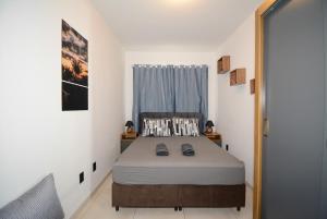 ein Schlafzimmer mit einem Bett in einem Zimmer mit einem Fenster in der Unterkunft Apartamento moderno numa ótima localização! in São José